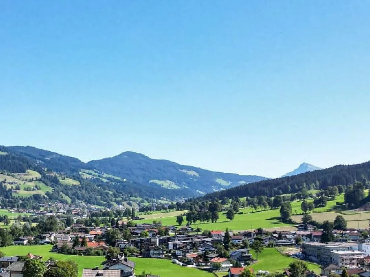 Blick in Richtung Kitzbüheler Horn über grüne Wiesen und Berge