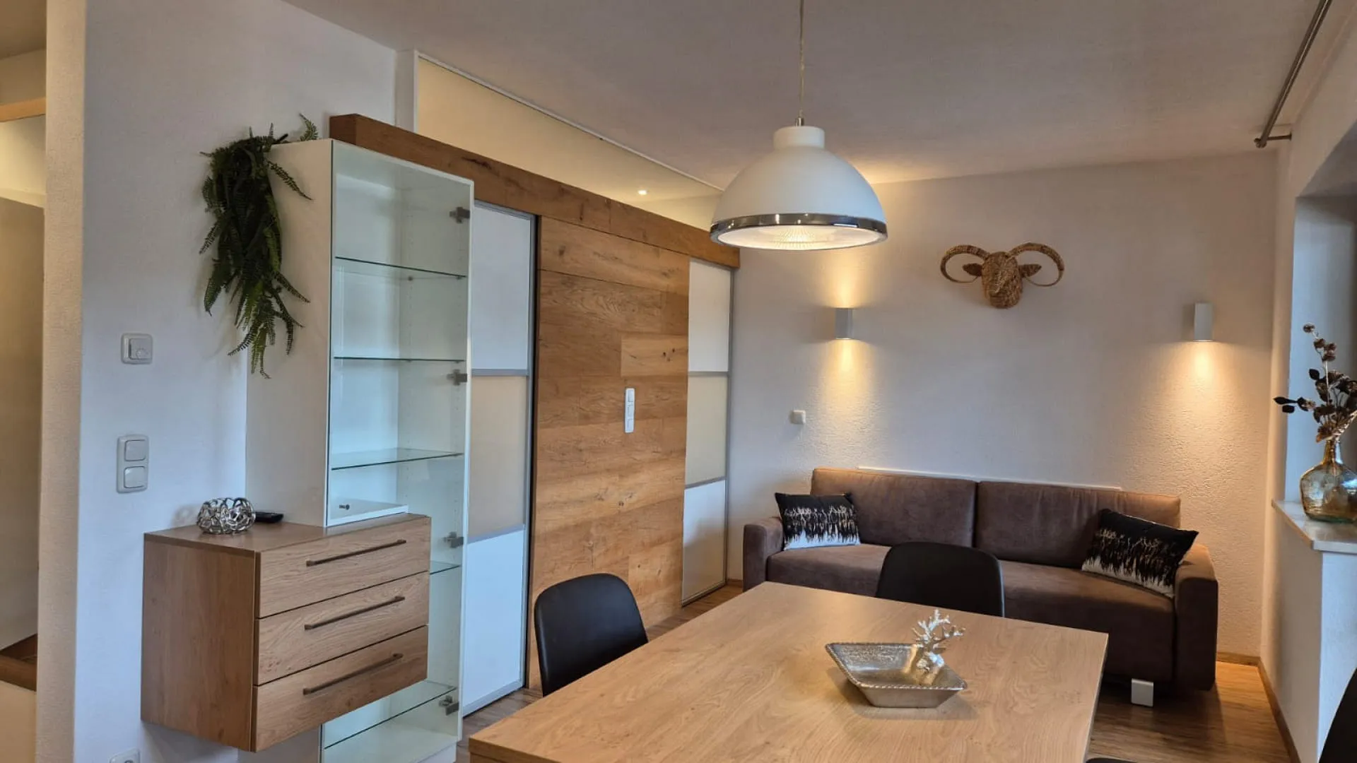 Modernes Wohnzimmer mit Holzregal, Sofa und Esstisch